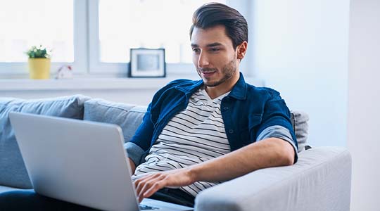 Man working at computer from couch